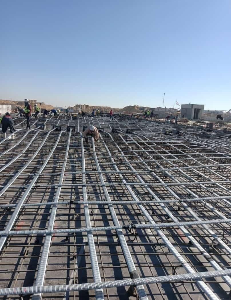 Install cable ducts inside the forms before pouring the concrete.  The concrete is poured with the cables unstretched inside the ducts.